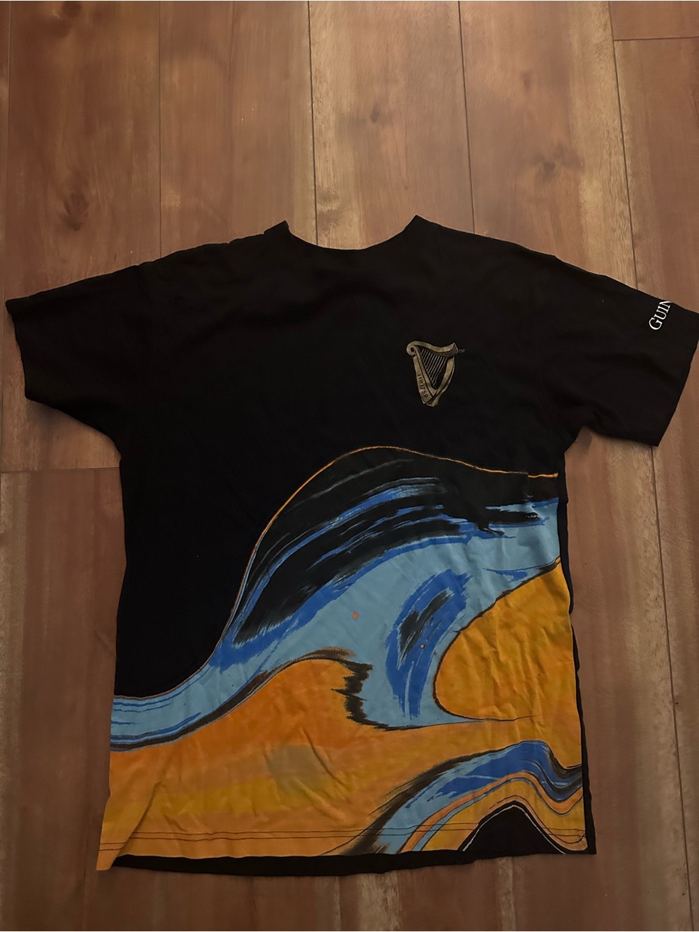Guinness Black Graphic Wave T-Shirt with Blue & Gold Artwork. Unisex.